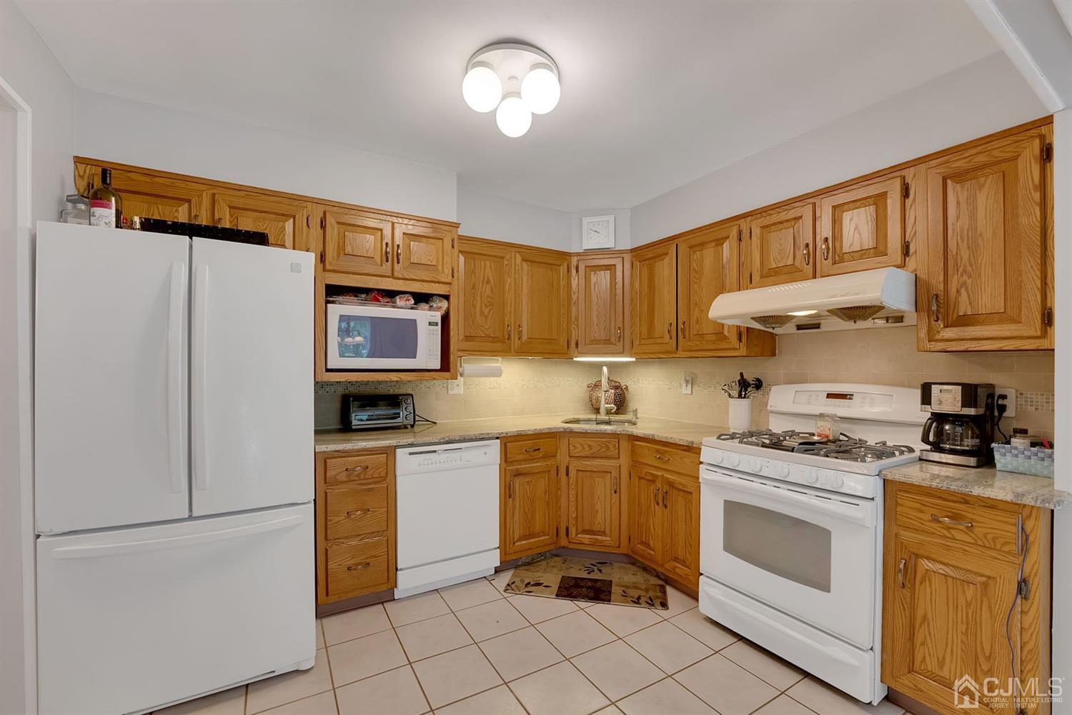 30 Savage Road Kendall Park, NJ 08824 - Photo 8 of 20 a kitchen with stainless steel appliances granite countertop a stove a sink dishwasher and a refrigerator
