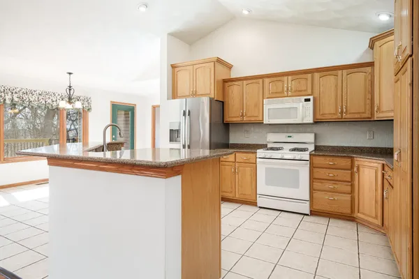 a kitchen with stainless steel appliances granite countertop a sink and a refrigerator