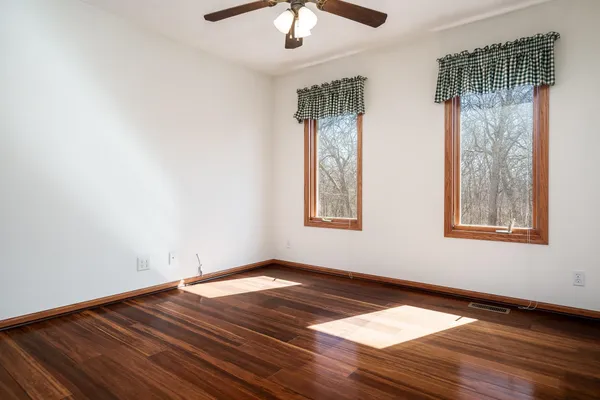 an empty room with wooden floor and entryway