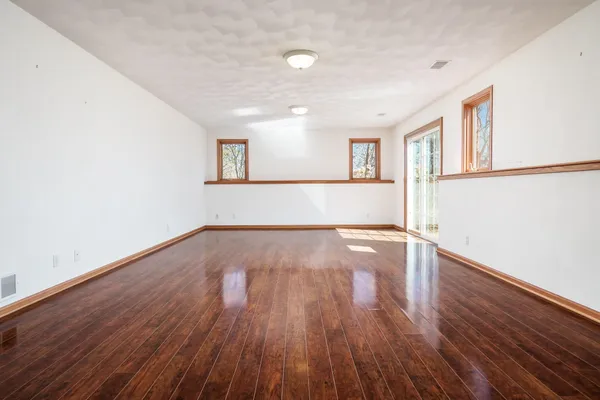 a view of an empty room with wooden floor