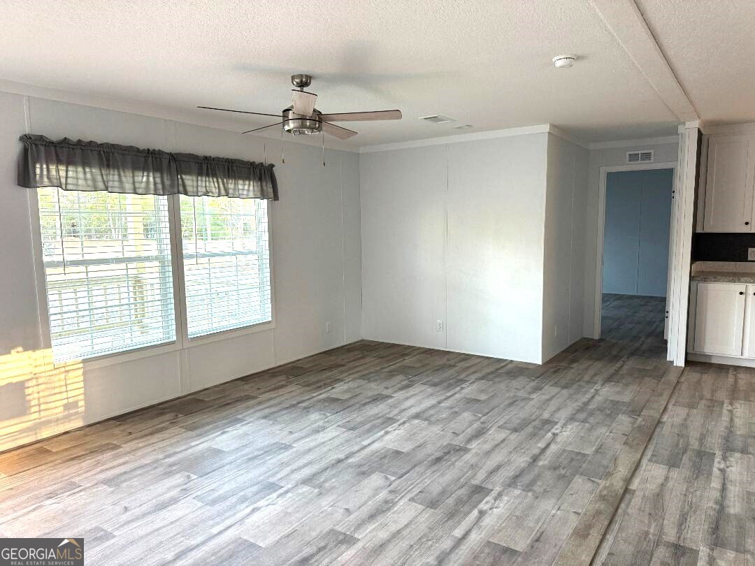 519 Wilson Road Twin City, GA 30471 - Photo 6 of 20 a view of an empty room with a window and wooden floor