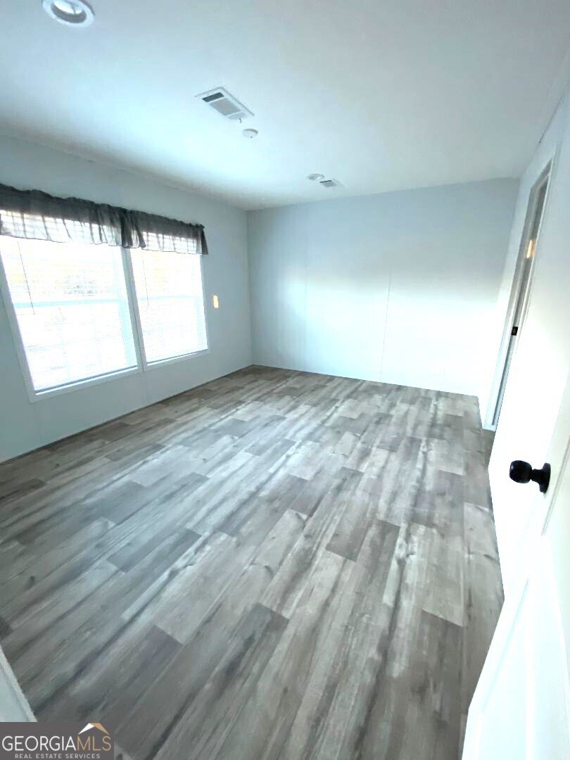 519 Wilson Road Twin City, GA 30471 - Photo 7 of 20 wooden floor in an empty room with a window