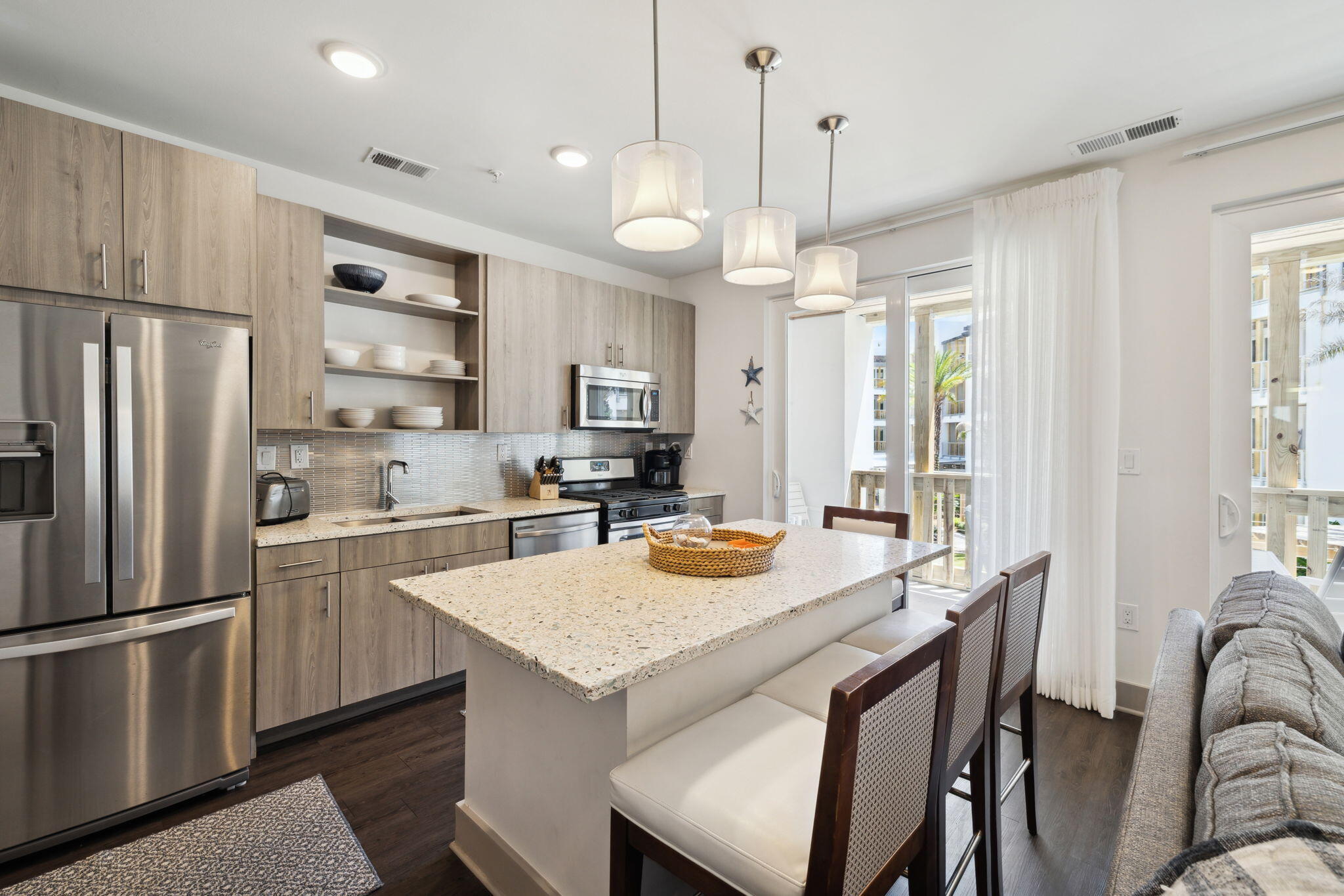 a kitchen with granite countertop a refrigerator a sink a stove a dining table and chairs