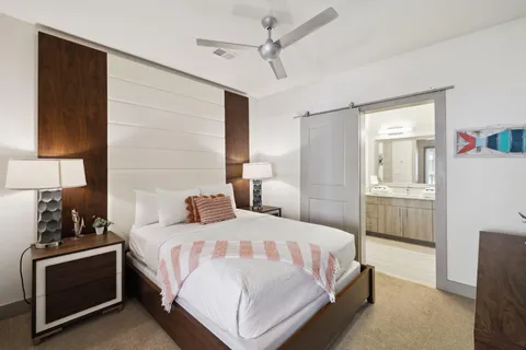 a bedroom with a bed and a lamp on the dresser