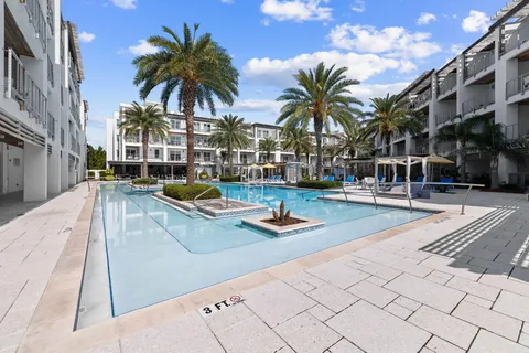a view of swimming pool with outdoor seating and house in the background