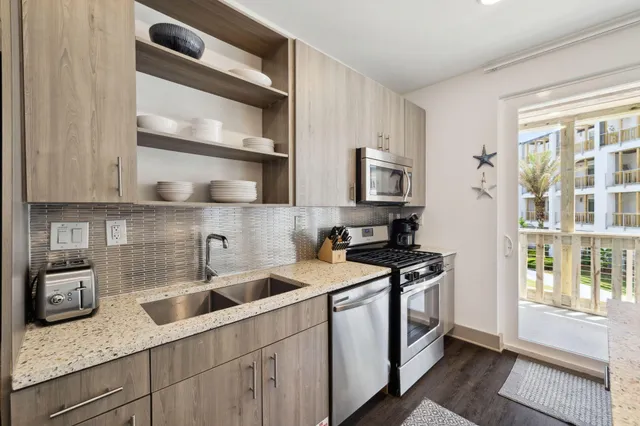 a kitchen with stainless steel appliances granite countertop a sink a stove and cabinets