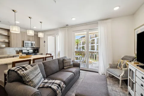 a living room with furniture a large window and a flat screen tv