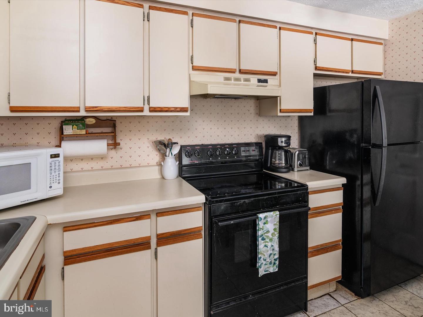 8028 Abbey Court, Unit C Pasadena, MD 21122 - Photo 7 of 12 a kitchen with stainless steel appliances granite countertop a stove a refrigerator and a microwave