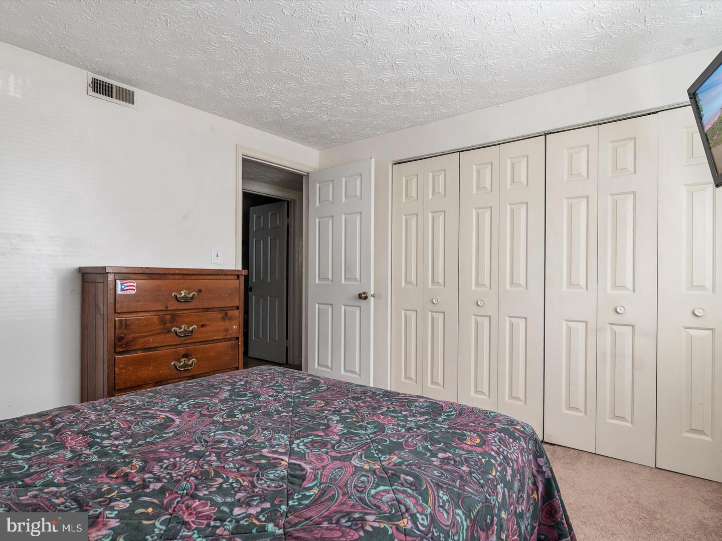 8028 Abbey Court, Unit C Pasadena, MD 21122 - Photo 10 of 12 a bedroom with a bed and a dresser