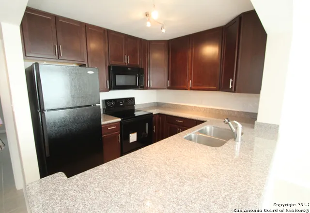 a kitchen with a refrigerator sink and cabinets