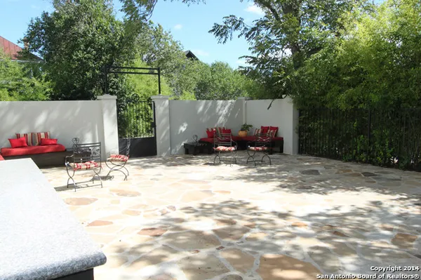 a view of backyard with table and chairs and potted plants