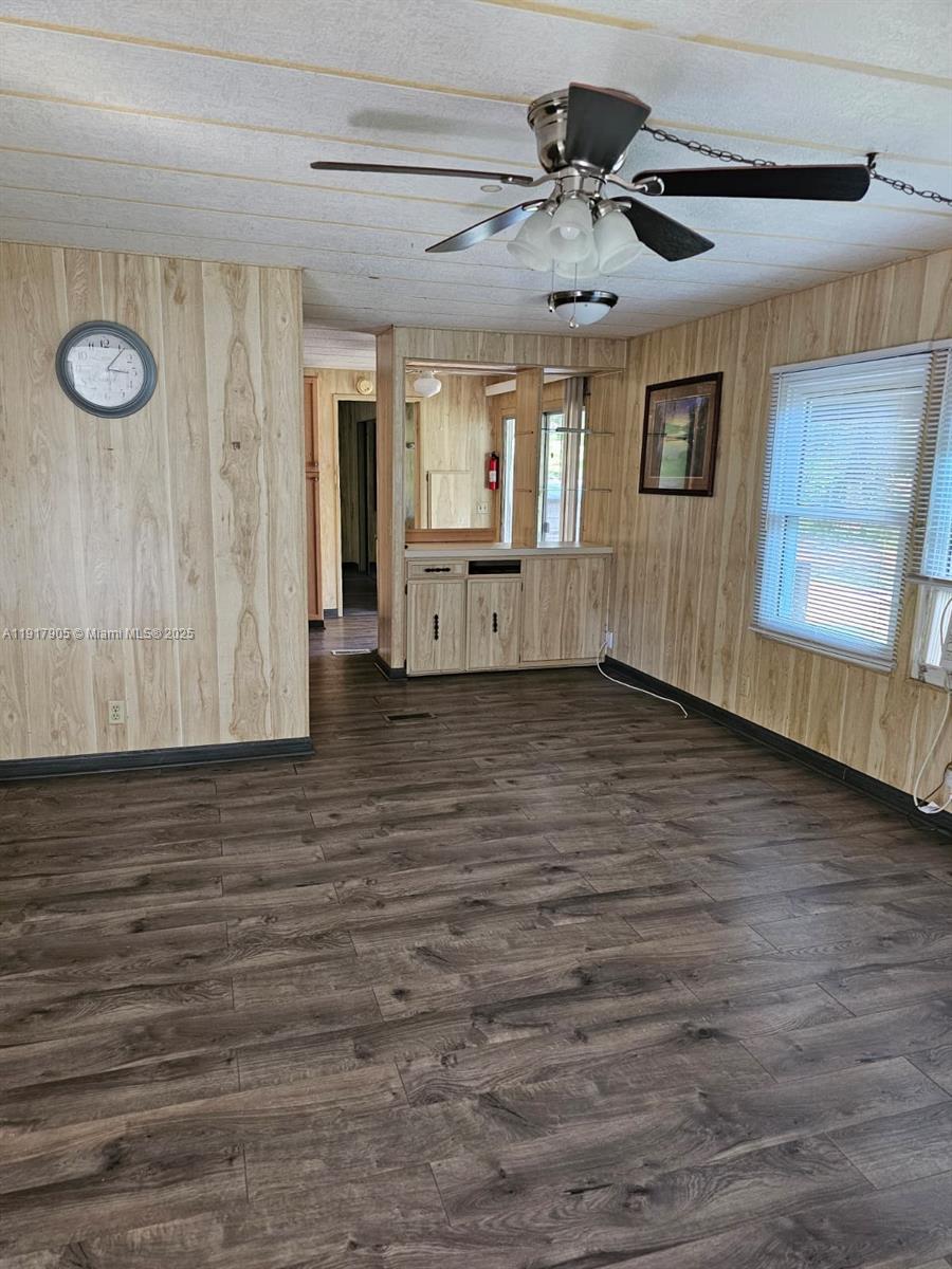 18620 Wildlife Trail, Unit 18620 Spring Hill, FL 34610 - Photo 4 of 19 a view of an empty room with wooden floor and a ceiling fan