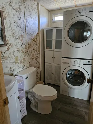 a white toilet sitting next to a bathroom sink and vanity