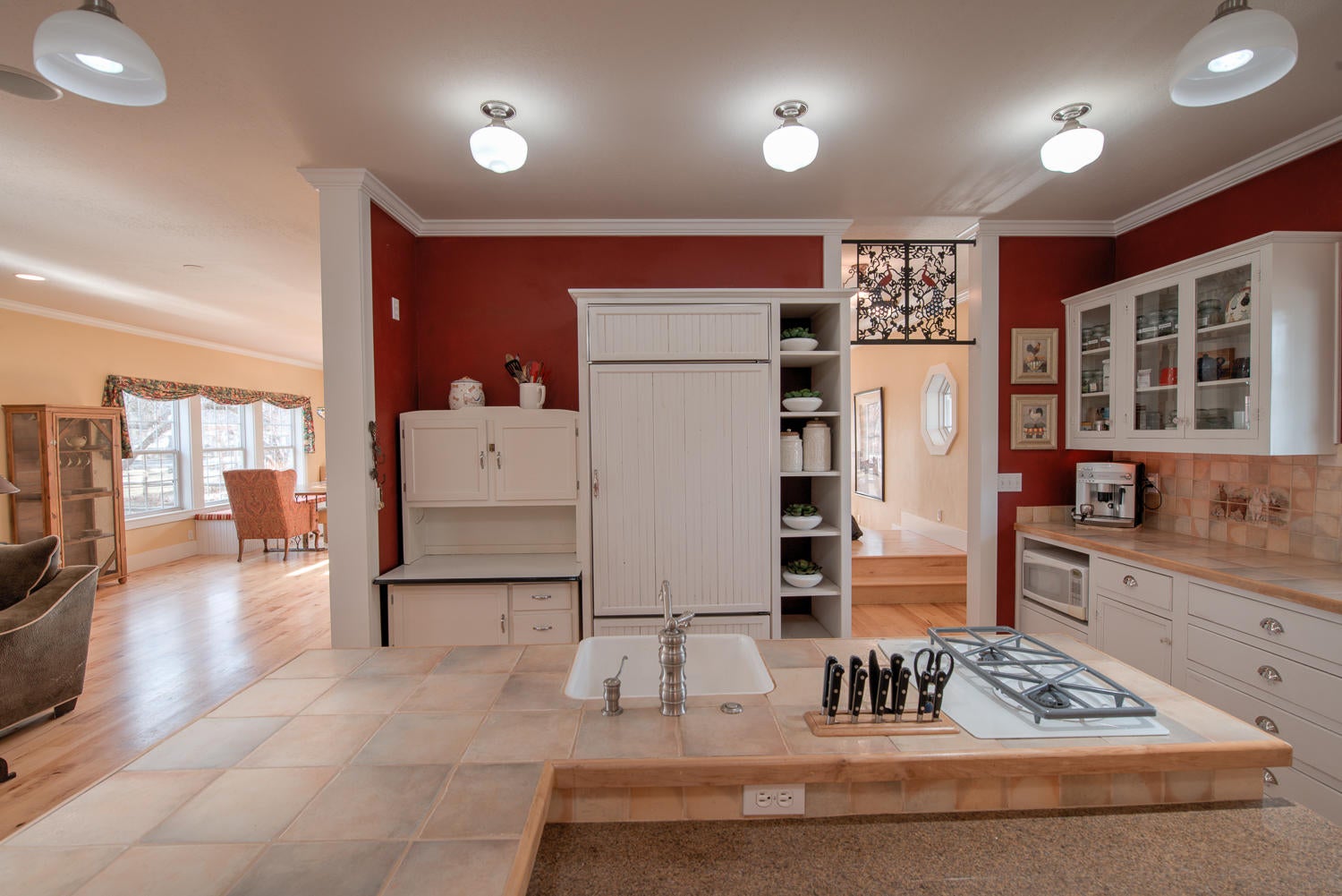 22222 Erickson Road Bend, OR 97701 - Photo 15 of 100 Island with built-in knife rack, Kitchen Aid 2-burner stove and farm sink with disposal. Antique transom over doorway to entry hall on right. Integrated front with wainscoting on Subzero fridge