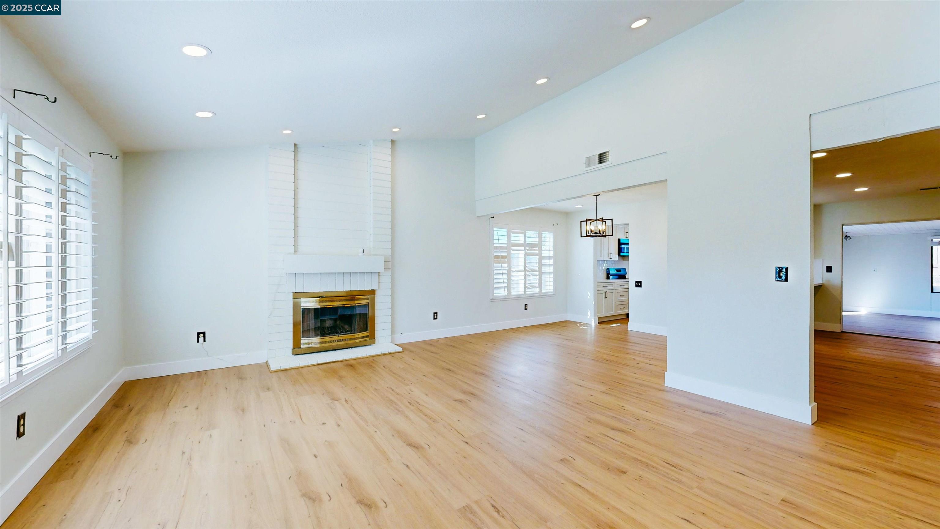 3743 Painted Pony Road Richmond, CA 94803 - Photo 12 of 56 an empty room with wooden floor fireplace and windows
