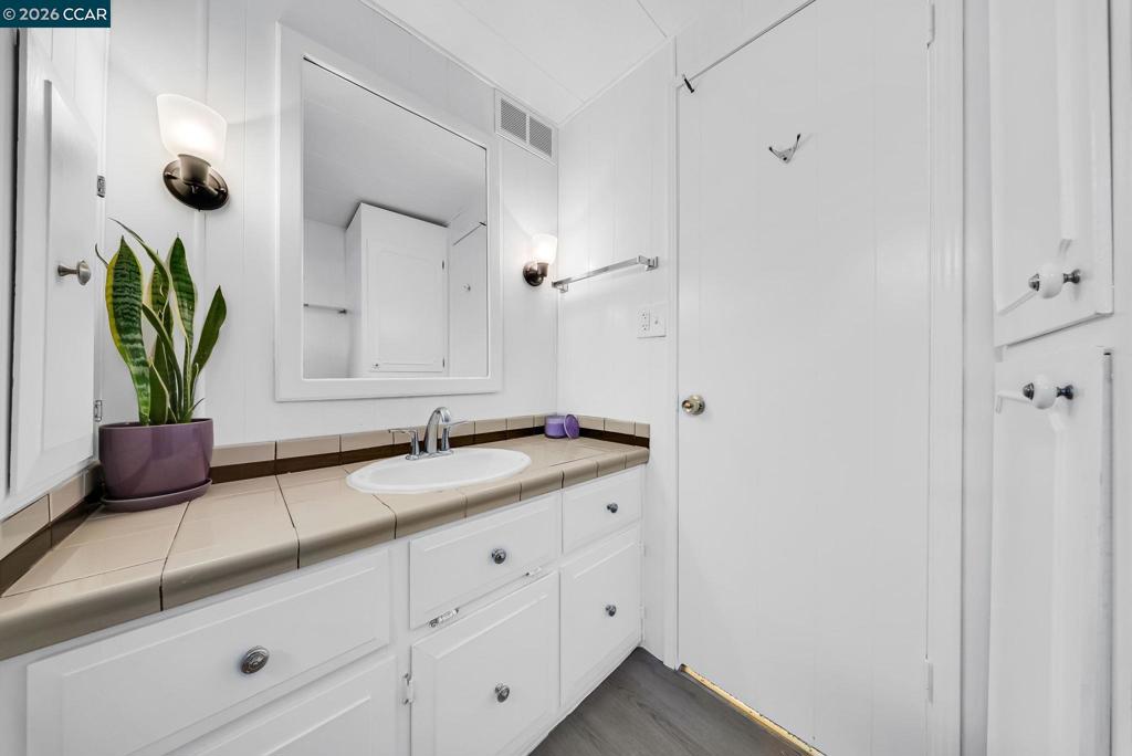 3466 Willow Pass Road Concord, CA 94519 - Photo 14 of 24 a bathroom with a granite countertop sink a mirror and shower