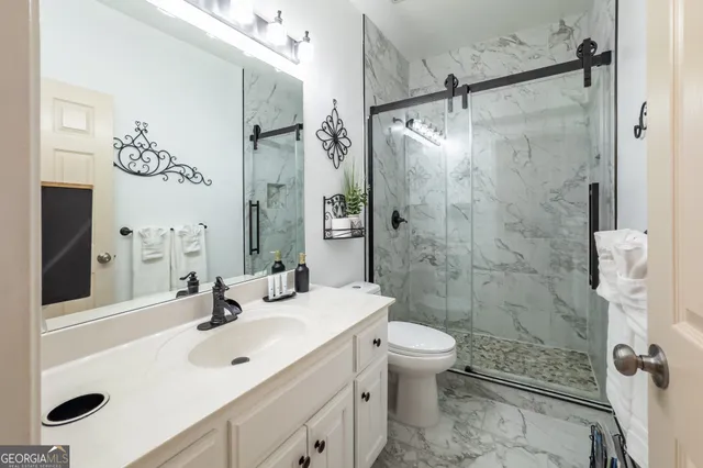 a bathroom with a sink toilet double vanity and shower