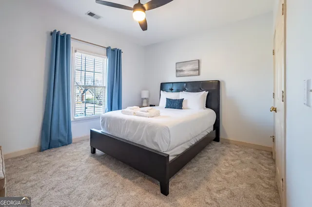 a large bed sitting in a bedroom next to a window
