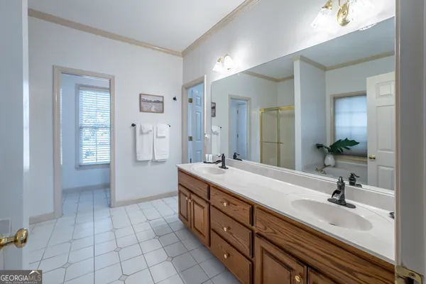 a spacious bathroom with a double vanity sink a mirror and a bathtub