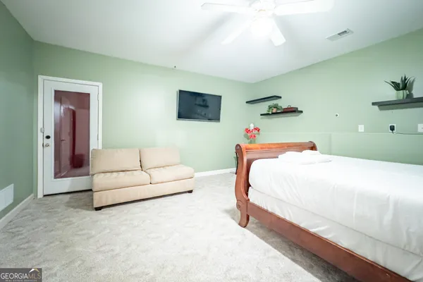 a bedroom with a white bed and a couch