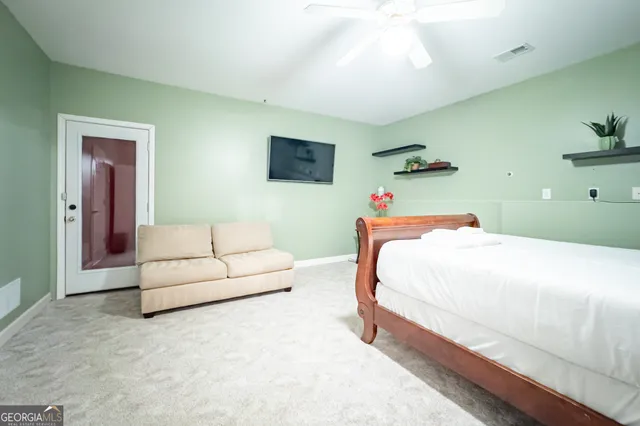 a bedroom with a white bed and a couch