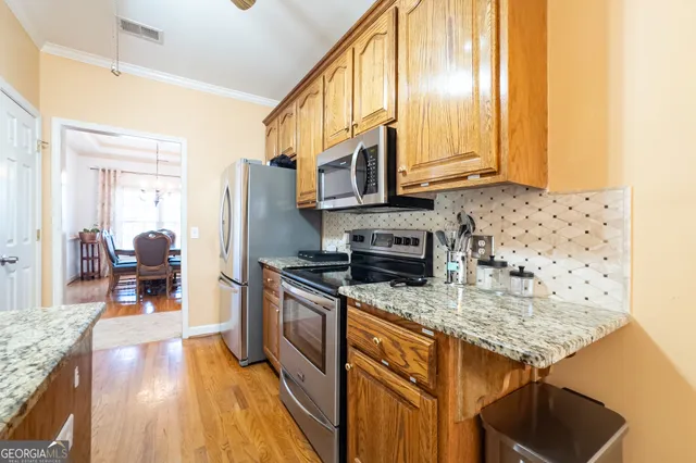 a kitchen with stainless steel appliances granite countertop a stove a sink and a microwave
