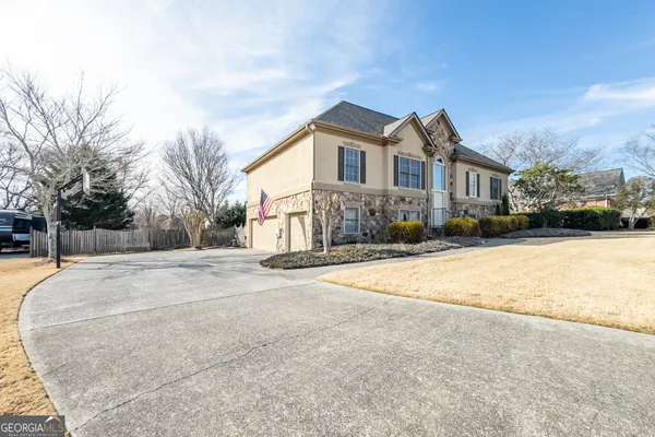a front view of a house with a yard covered in snow