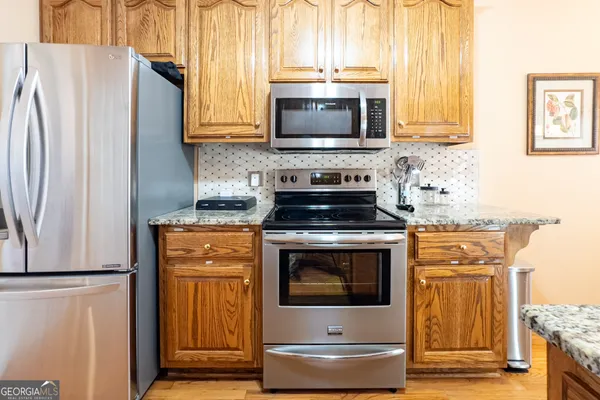 a kitchen with stainless steel appliances wooden cabinets and a stove top oven