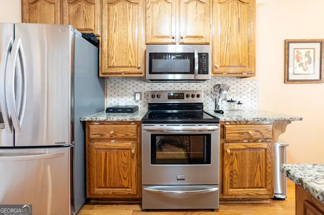 a kitchen with stainless steel appliances wooden cabinets and a stove top oven