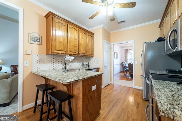 a kitchen with granite countertop a table chairs stove and refrigerator