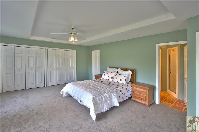78491 Avenue 41 Bermuda Dunes, CA 92203 - Photo 10 of 16 a bedroom with a bed and a chandelier