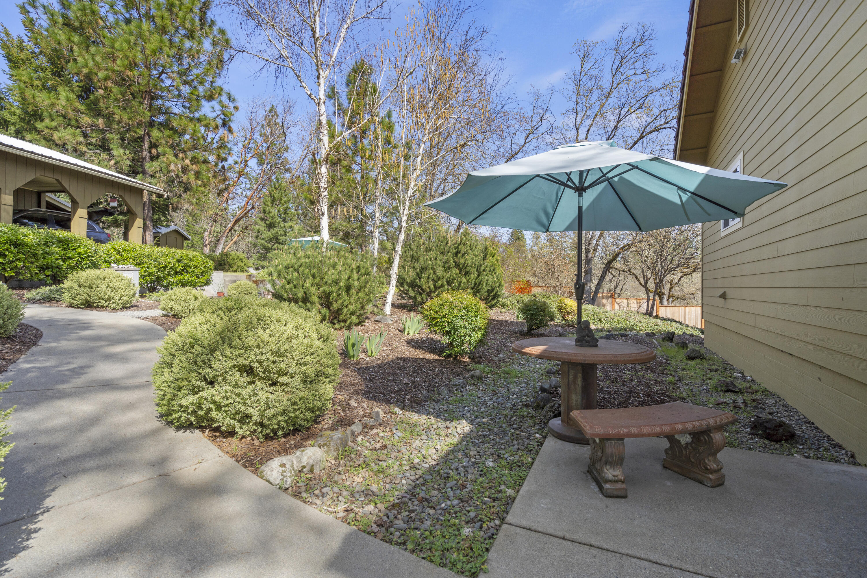 4874 Upper River Road Grants Pass, OR 97526 - Photo 49 of 66 a view of a table and chairs under an umbrella in backyard