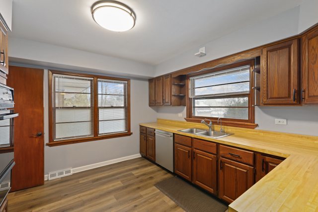 28W777 Garys Mill Road Winfield, IL 60190 - Photo 11 of 47 a kitchen with stainless steel appliances granite countertop a sink and cabinets with wooden floor