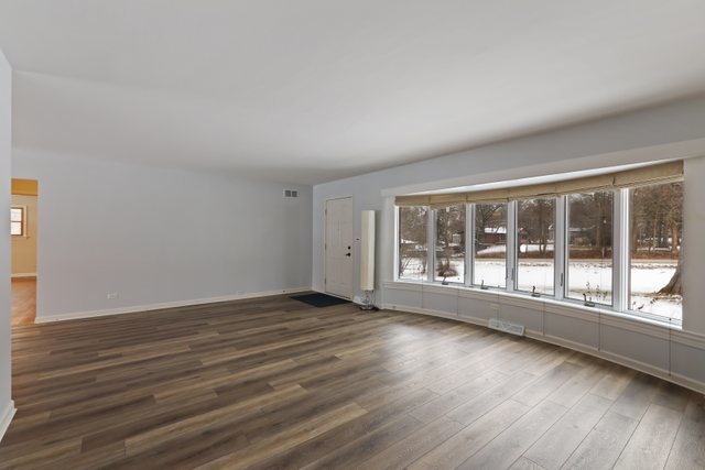 28W777 Garys Mill Road Winfield, IL 60190 - Photo 7 of 47 a view of an empty room with wooden floor and a window