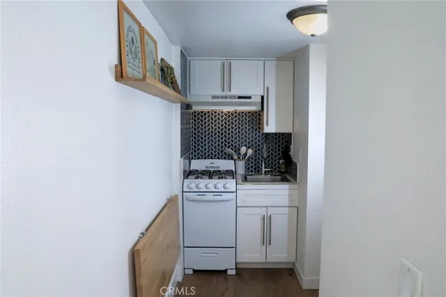 a white refrigerator freezer and a stove sitting inside of a kitchen