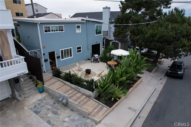 an aerial view of a house with a yard fire pit and furniture