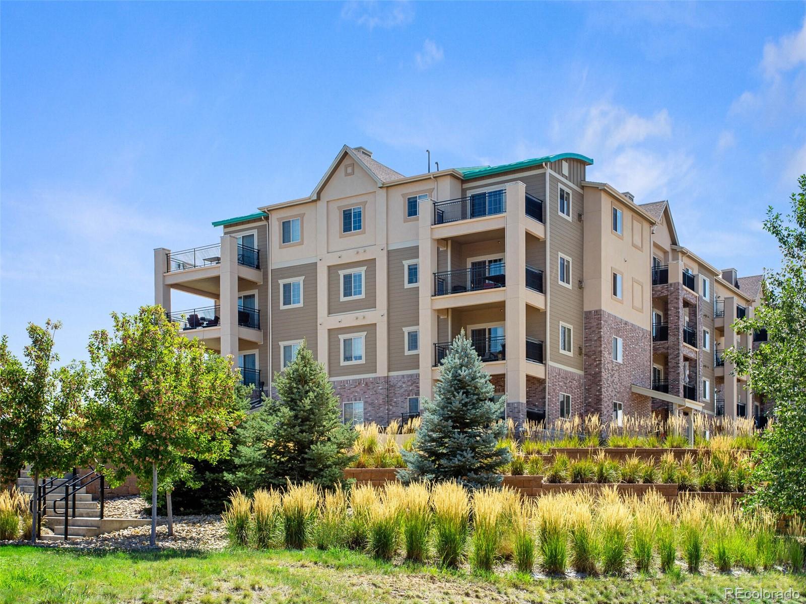 9258 Rockhurst Street, Unit 405 Highlands Ranch, CO 80129 - Photo 1 of 32 a front view of a residential apartment building with a yard