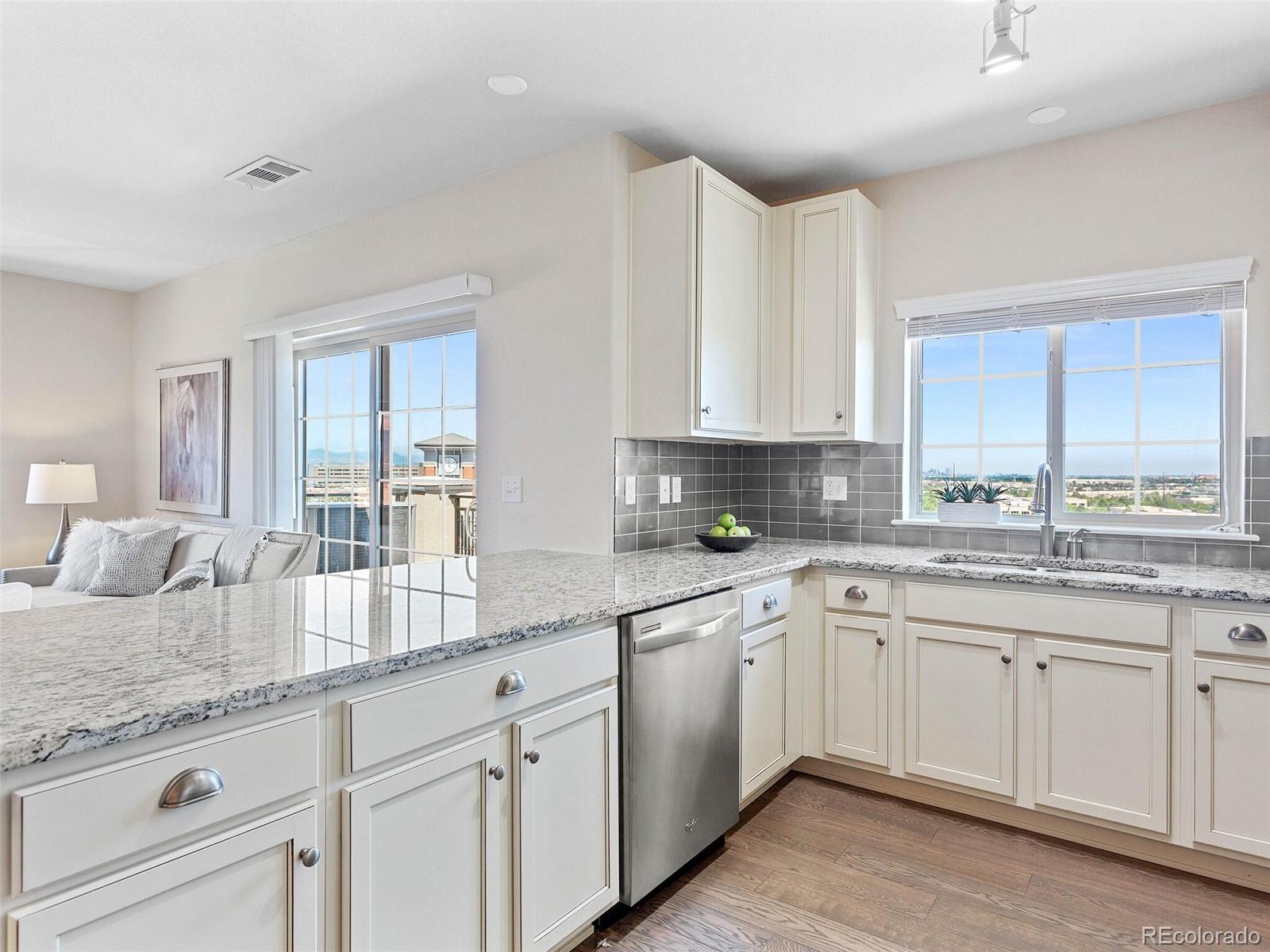 9258 Rockhurst Street, Unit 405 Highlands Ranch, CO 80129 - Photo 11 of 32 a kitchen with granite countertop white cabinets and white appliances