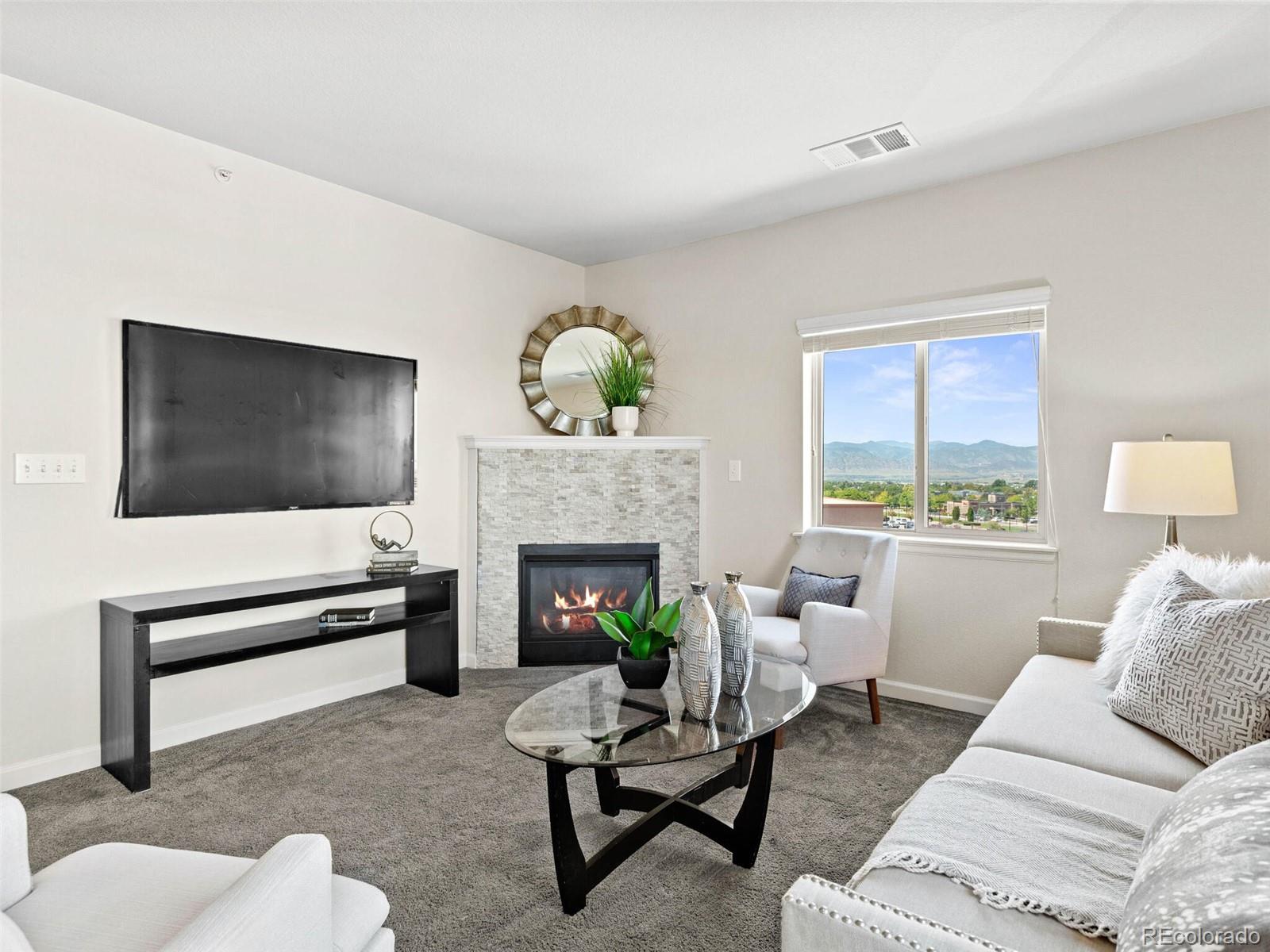 9258 Rockhurst Street, Unit 405 Highlands Ranch, CO 80129 - Photo 14 of 32 a living room with furniture a flat screen tv and a fireplace