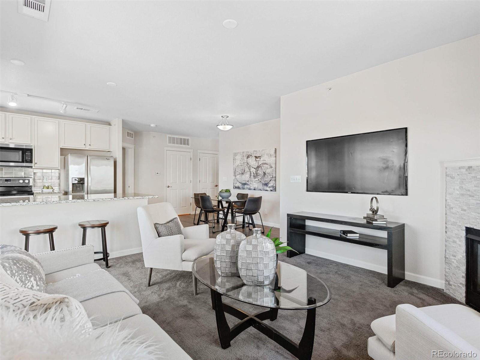 9258 Rockhurst Street, Unit 405 Highlands Ranch, CO 80129 - Photo 17 of 32 a living room with furniture and a flat screen tv