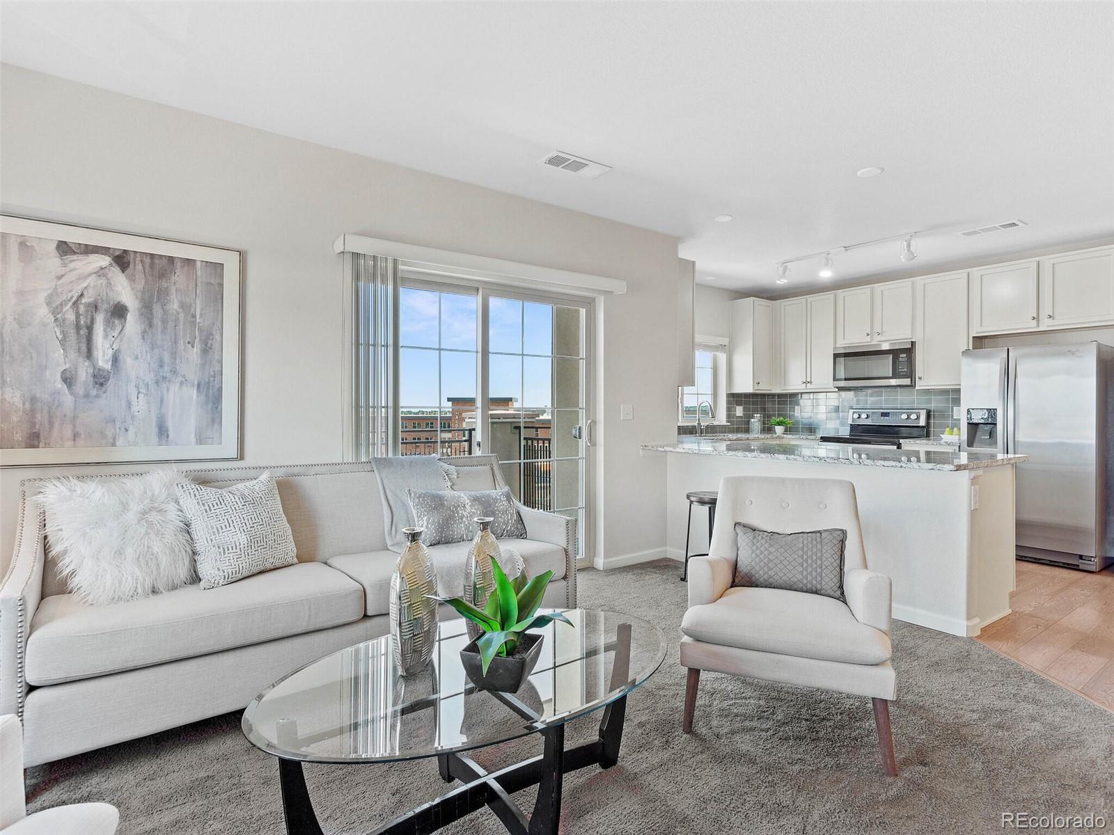 9258 Rockhurst Street, Unit 405 Highlands Ranch, CO 80129 - Photo 18 of 32 a living room with furniture and kitchen view