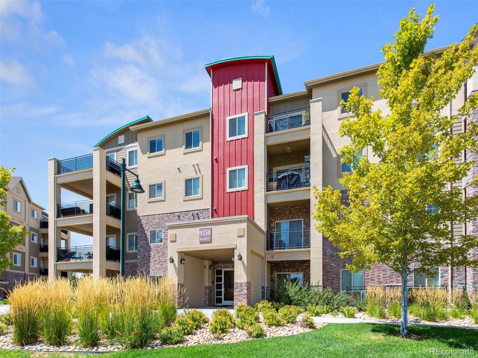 9258 Rockhurst Street, Unit 405 Highlands Ranch, CO 80129 - Photo 3 of 32 a front view of a multi story residential apartment building with yard