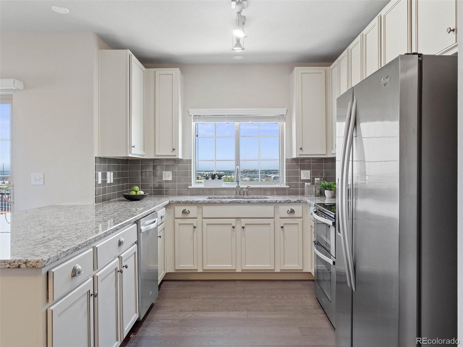 9258 Rockhurst Street, Unit 405 Highlands Ranch, CO 80129 - Photo 10 of 32 a kitchen with white cabinets stainless steel appliances and a counter space