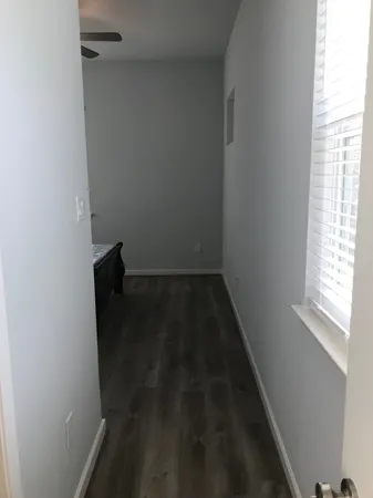 a view of a hallway with wooden floor and closet