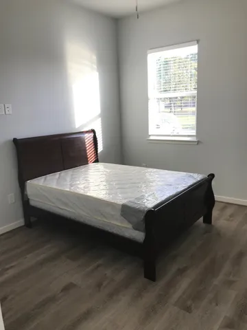 a bed sitting in a bedroom next to a window