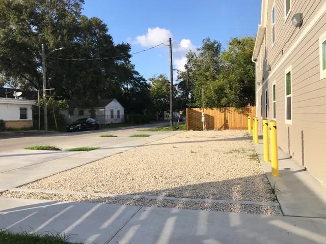 a view of a white house with many windows next to a road