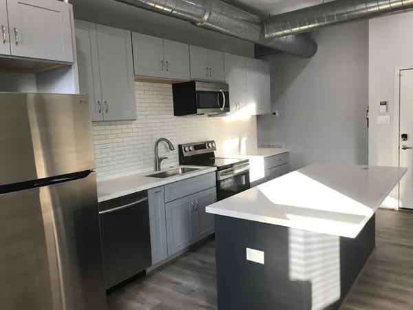 a kitchen with a sink a refrigerator a microwave a sink and cabinets