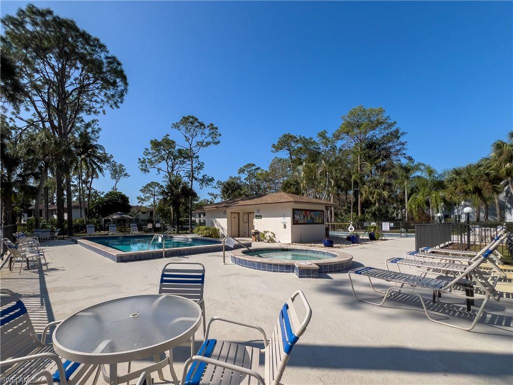1833 Courtyard Way, Unit E204 Naples, FL 34112 - Photo 16 of 18 a view of a patio with swimming pool table and chairs