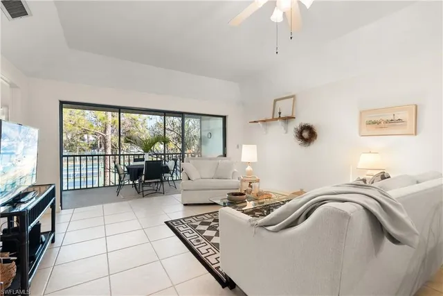 a living room with furniture and a floor to ceiling window