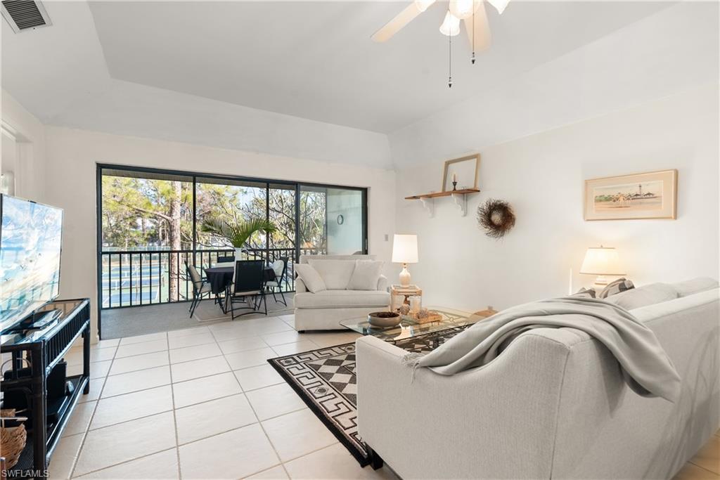 1833 Courtyard Way, Unit E204 Naples, FL 34112 - Photo 2 of 18 a living room with furniture and a floor to ceiling window